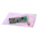 A green circuit board in a clear pink anti-static bag.