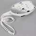 A white Conair wall mount hair dryer with a cord.