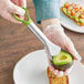 A hand using a Choice avocado slicer to peel an avocado.