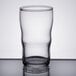 A Libbey clear juice glass with a rim on a table.