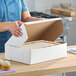 A white rectangular cake or bakery box with a hinged lid, suitable for packaging cakes or baked goods.