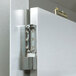 The metal door of a Traulsen Correctional Roll In Refrigerator with a lock and hinge.