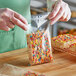 A person holding a Choice plastic resealable bag of colorful cereal.