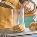 A person putting cookies into a Choice clear plastic bag.