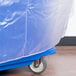 A blue plastic cover on a Cambro food bar cart with wheels.