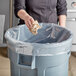 a person throwing a paper in a trash can