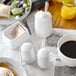 A breakfast table with a white Tablecraft salt shaker on it.