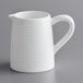 A Tablecraft white melamine creamer with a handle on a gray surface.