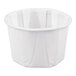 A small white paper souffle or portion cup.