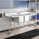 A Regency stainless steel two compartment sink with drainboards on a counter.