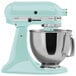 A blue KitchenAid tilt head mixer with a stainless steel bowl.