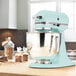 A blue KitchenAid Artisan Series mixer on a counter.