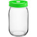 A clear glass jar with a green metal lid with a straw hole.