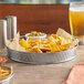 A Tablecraft lattice stainless steel platter with a bowl of chips and a glass of beer on it.