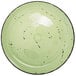 A lime green porcelain plate with black specks.