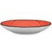A white porcelain pasta bowl with a red rim.