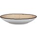 An International Tableware wheat porcelain pasta bowl with a black border.