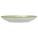 A white porcelain saucer with a green rim.