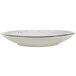 A white porcelain saucer with a black speckled rim.
