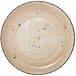 A close-up of an International Tableware Rotana wheat coupe porcelain plate with black dots.