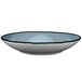 A white porcelain bowl with a blue and white pattern on the rim.