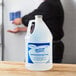 A man pouring Kutol Health Guard Light Linen foaming hand sanitizer from a gallon bottle.