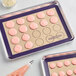 A tray of pink cookies on a Baker's Lane purple silicone baking mat.