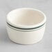 An Acopa ivory stoneware ramekin with green stripes.