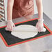 A woman rolling dough on a Baker's Lane perforated silicone baking mat.