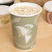 A white Eco-Products Evolution World soup cup on a table with food inside.