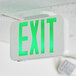 A white Lavex exit sign with green text on a white ceiling.