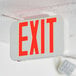 A white rectangular Lavex exit sign with red text.