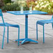 A blue Lancaster Table & Seating outdoor table with two chairs.