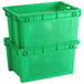 Two green vented agricultural crates stacked on top of each other.