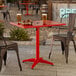 A rectangular red powder-coated aluminum outdoor dining table with an umbrella hole.