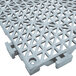 A grey plastic floor mat with triangular holes.