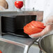 A person using a Vollrath straight blade assembly to slice tomatoes.