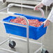 A person holding a blue Choice meat lug full of meat.