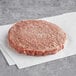 An AngusPure New Zealand grass fed beef burger patty on a white surface.