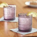 Two Fortessa Jupiter purple glasses with ice and lemon slices on a napkin.