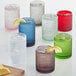 A group of sage green Fortessa Jupiter rocks glasses with a drink and lemon slices.