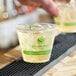 A clear 9 oz. compostable plastic cold cup filled with ice and a light-colored beverage, featuring the Greenware logo and branding.