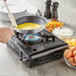 A pan of eggs cooking on a Choice portable stove.