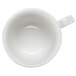 A bone white tea cup with a handle shaped like a book.