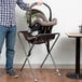 A man holding a Koala Kare brown infant seat.