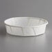 A white paper Genpak souffle cup on a gray surface.