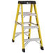 A yellow Bauer Corporation fiberglass ladder with black top.