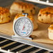 An AvaTemp oven thermometer in a tray of baked goods.