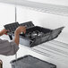 A man opening a black Choice Chafer Tote box with silver containers inside.