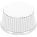 A white fluted ramekin on a white surface.